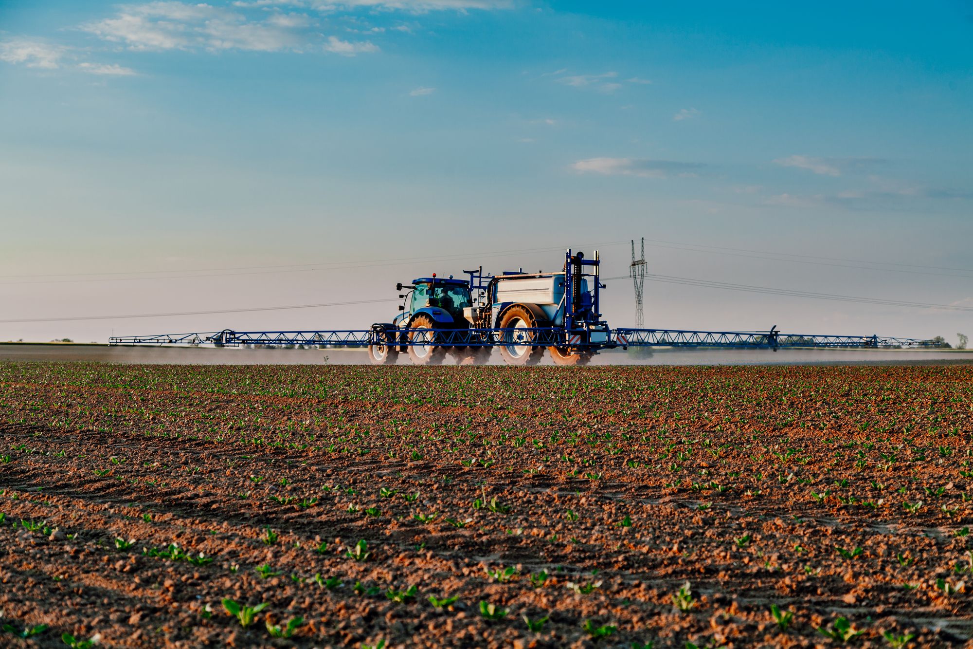 Agricultural sprayer with a horizontal spray bar (boom) is used to evenly distribute the pesticide spray solution across the field.